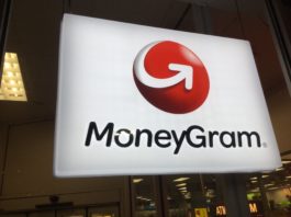 Glowing MoneyGram sign hanging from the ceiling, with an ATM behind it.